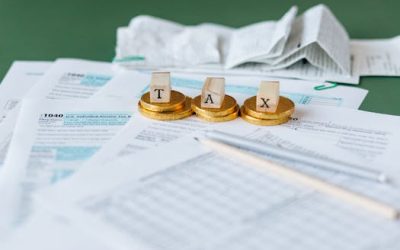 Close-up of tax forms, receipts, and coins symbolizing financial accounting and taxes.